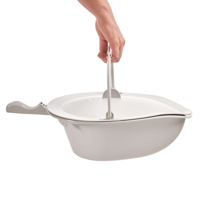 Etac Clean Commode Pan Lid positioned in a home environment such as a bedroom or bathroom, demonstrating its discreet appearance.