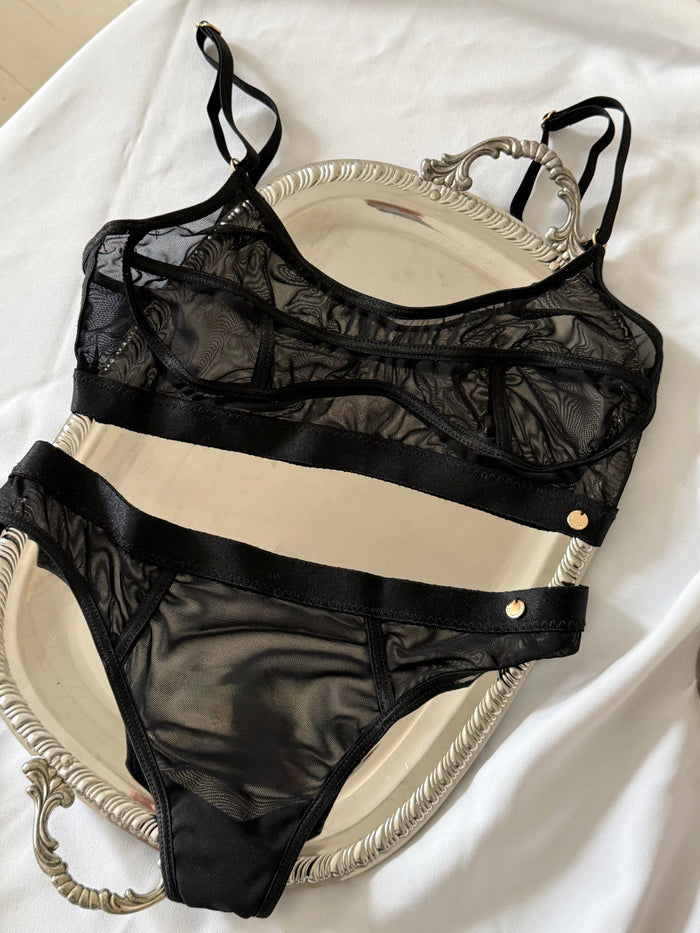 zwarte mesh lingerie set op zilver blaadje en wit laken