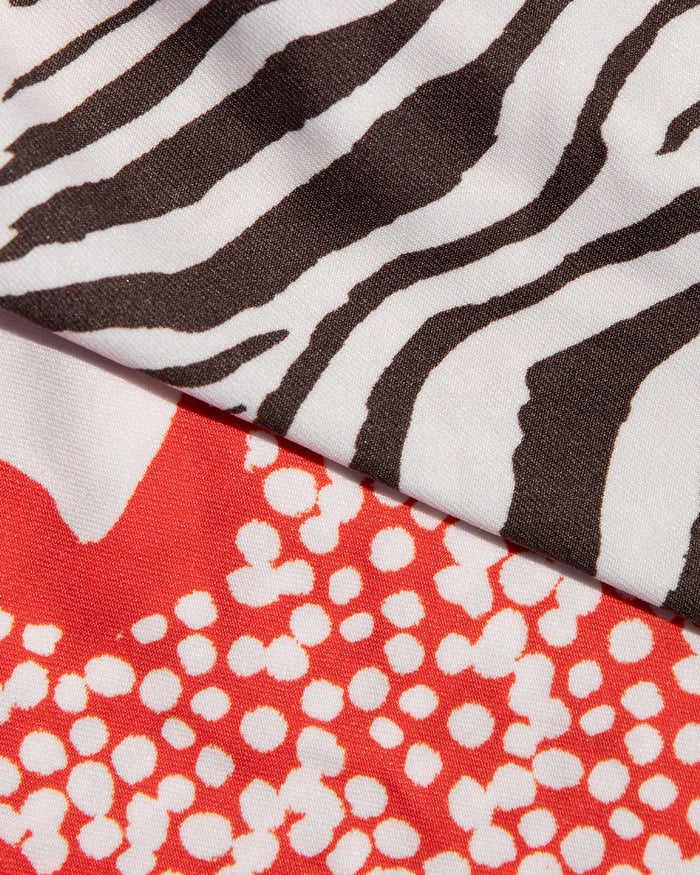Close-up of black and white animal print and red hibiscus bloom print fabric used in the LSPACE Animal Hibiscus Bloom Banning Bikini Top.