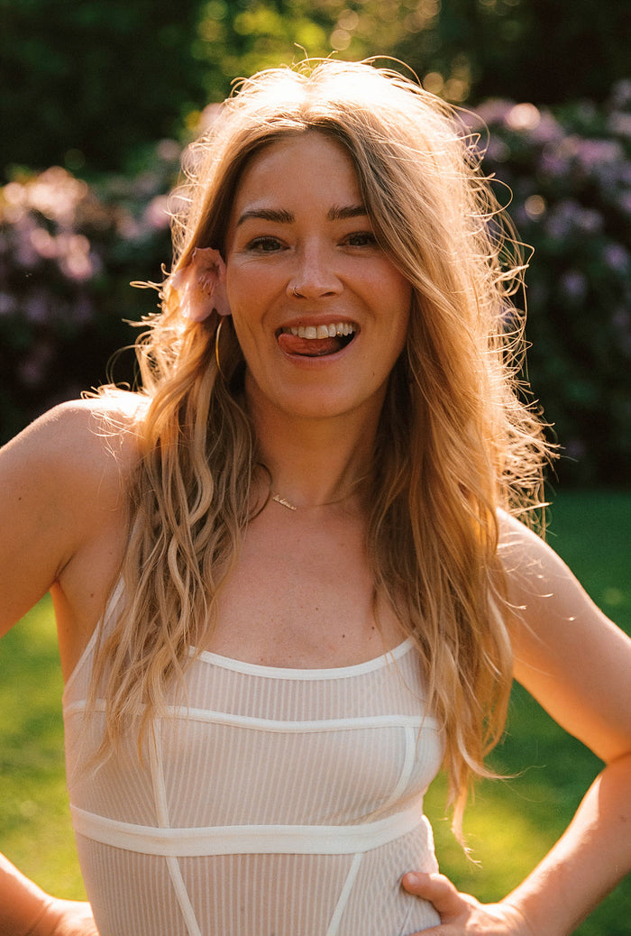 geraldine kemper met bloem in haar en tong uit mond in lingerie