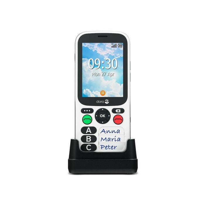 Doro 780X Simple Mobile Phone mobile phone in its charging cradle on a table.