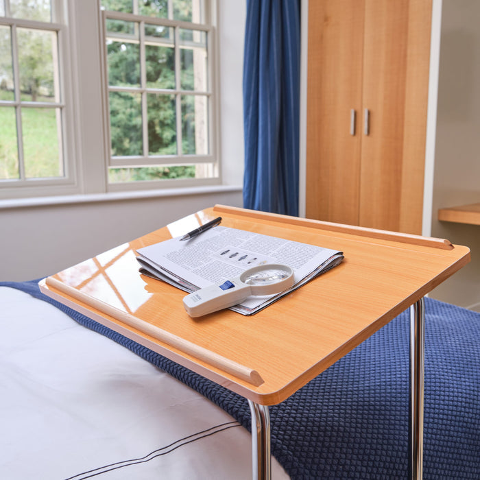 Close-up of hands adjusting the height or tilt of NRS Divan Overbed Table, showing the easy-turn knobs.